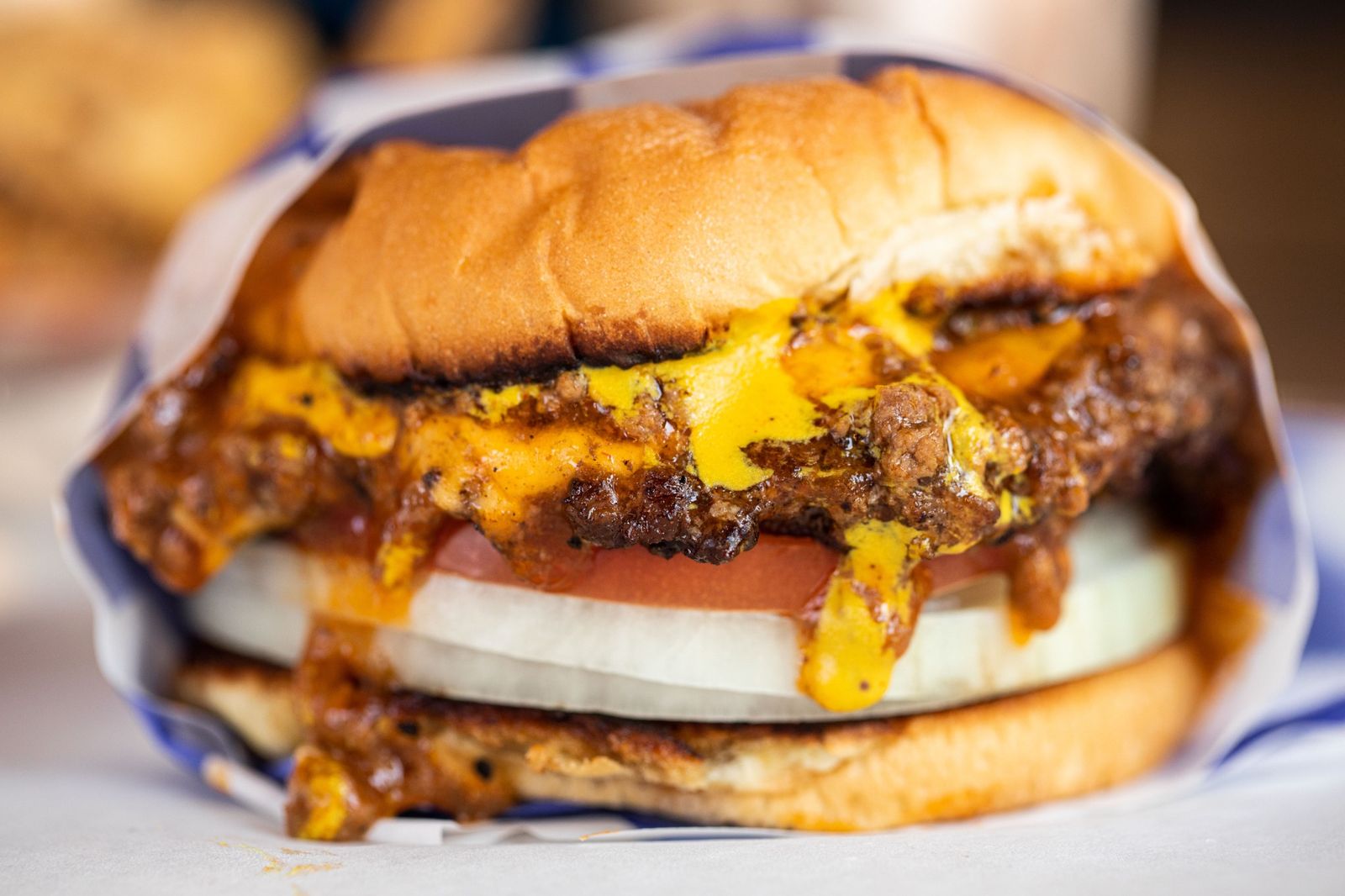 Double smash burger with melted cheese, tomato and onion in a wrapper